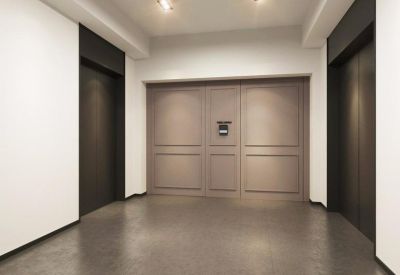 Sleek elevator lobby with dark wood panels and neutral-toned doors.
