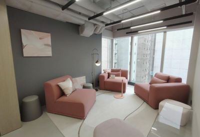 Stylish lounge featuring pink modular sofas, a grey feature wall, and contemporary linear lighting.