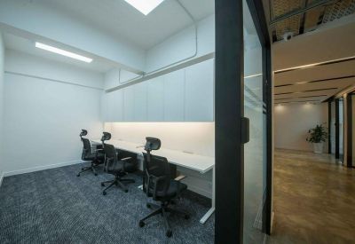 Private office suite with three black ergonomic chairs and integrated desk lighting.