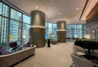 Spacious communal lounge with curved gold pillars and floor-to-ceiling city views.