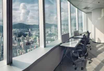 Open-plan office desks positioned along a window wall overlooking the city.