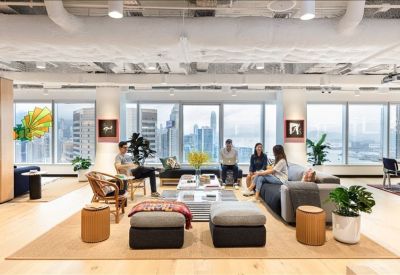Lounge area with modern sofas and large windows overlooking the city skyline.