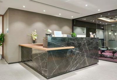 Reception area featuring a dark marble desk and warm overhead lighting.