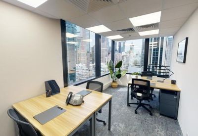 Three-person office with large windows and a corner desk setup.