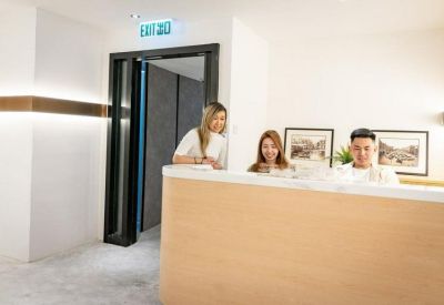Modern reception desk with staff and a black-framed doorway.