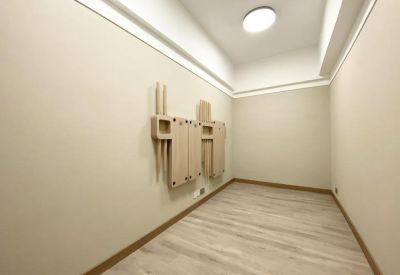 Bright minimalist room with light wood flooring and a circular ceiling light.