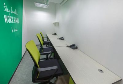 Private office space with desks, lime green chairs, and a wall decal.