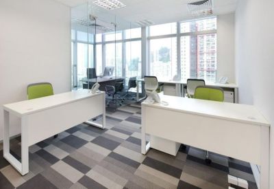 Sunlit private office with white desks and checkered carpet.