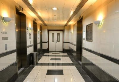 Polished elevator lobby with bright wall sconces and patterned floor tiling.