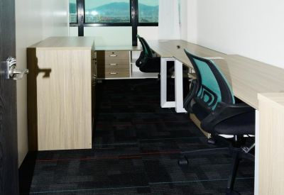 Private office suite with wood-look desks, teal ergonomic chairs, and a window view.