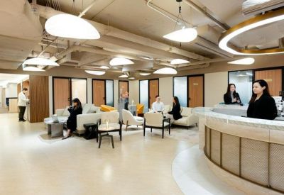 Spacious communal lounge with modern seating and circular pendant lighting.