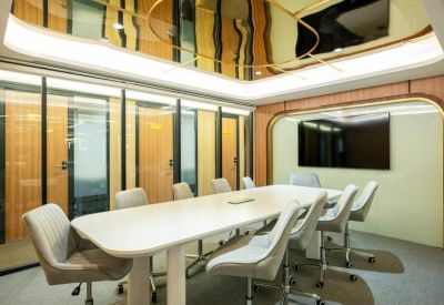 Modern conference room with a large white table and gold-accented ceiling mirror.