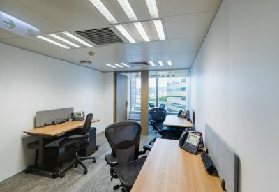 Internal four-person office suite with light wood desks and ergonomic black chairs.