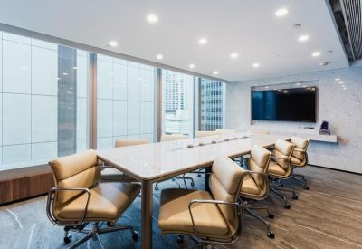 Professional meeting room featuring a long marble table, tan leather chairs, and city views.