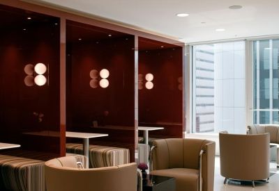 Private dark wood booths with warm lighting and comfortable armchairs.