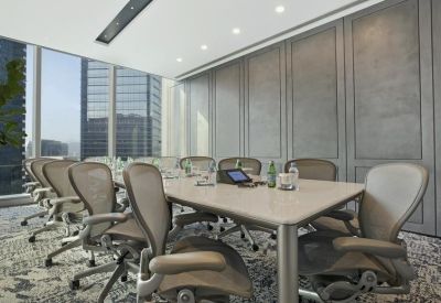Bright boardroom featuring a large table, ergonomic chairs, and floor-to-ceiling windows.