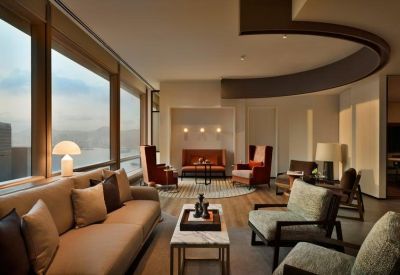 Elegant lounge area with plush sofas and large windows showing a hazy mountain view.
