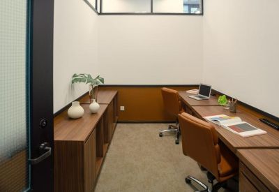 Private internal office suite with two workstations and warm wood cabinetry.
