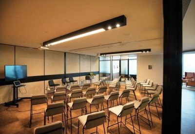 Versatile seminar room with multiple rows of chairs and a large presentation screen.