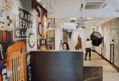 Industrial-style reception area with a dark metal desk and a vintage radio-themed wall graphic.