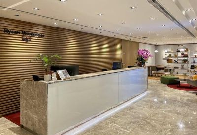 Sleek reception desk with a marble front and wood-slatted backdrop.