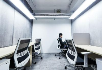 Bright open-plan office space with rows of ergonomic white chairs and desks.