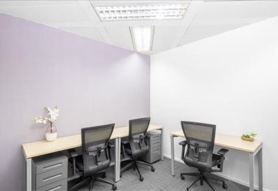 Bright, three-person private office with light wood desks and ergonomic chairs.