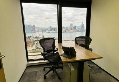 Private office for two featuring a wooden desk overlooking the Victoria Harbour skyline.