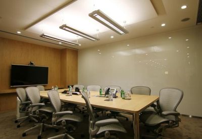 Professional boardroom with light wood table and modern ergonomic chairs.