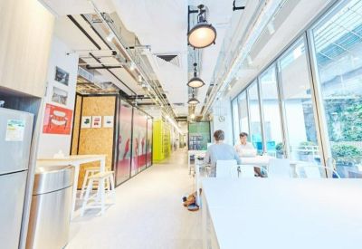 Long communal dining area and hallway with industrial lighting and large windows.