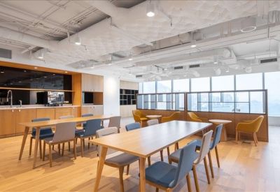 Modern communal kitchen and dining area with high-top tables and exposed industrial-style ceiling.