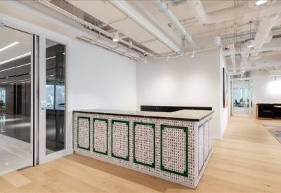 Professional reception desk featuring a decorative tile pattern and light wood flooring.