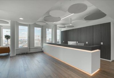Sleek reception desk with a dark feature wall and modern lighting fixtures.