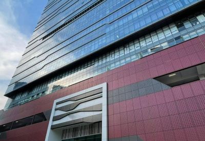 Exterior view of the modern glass and red-paneled facade of TML Tower.