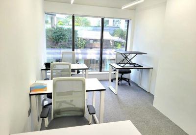 Compact private office suite with ergonomic white chairs and a large window.