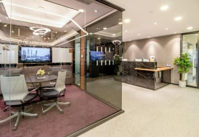 Professional reception area with a dark marble desk and an adjacent glass meeting room.