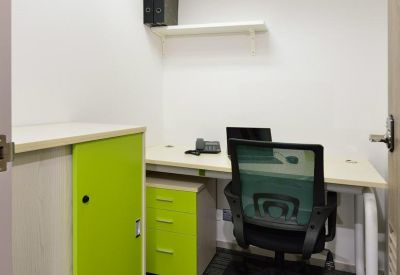 Private single-person office with a white desk and lime green storage cabinet.