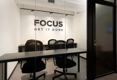A modern meeting room with glass walls and motivational wall graphics.