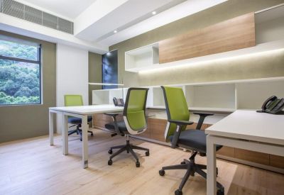 Modern two-person office suite with green ergonomic chairs and garden views.