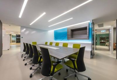 Large conference room with lime green chairs and a long wooden table.