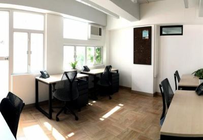 Private office suite with multiple workstations, black chairs, and large windows.