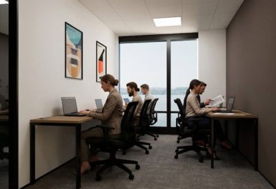 Team members working at desks in a private office suite with large windows and wall art.
