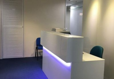 Bright reception desk with minimalist white finishes and integrated blue LED accent lighting.