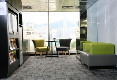 Bright lounge area with colorful armchairs and a view of the city skyline.