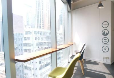 Window-side breakfast bar seating with yellow chairs and city views.