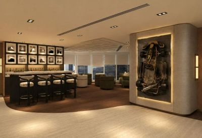 Spacious lounge area at Tower One, Lippo Centre featuring a bar, racing-themed wall art, and warm lighting.