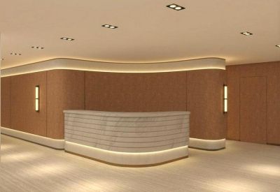 Curved wood-paneled reception desk with integrated warm LED lighting strips.