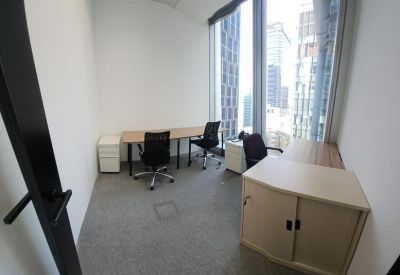 Bright private office with two desks and floor-to-ceiling city views.