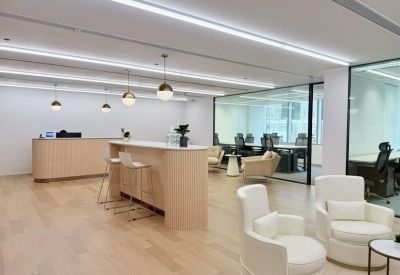 Spacious communal breakout space with a curved breakfast bar, white stools, and comfortable seating.