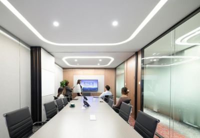 Sleek conference room with a long white table and integrated recessed lighting in the ceiling.